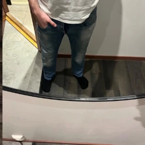 Replay Anbass jeans  - Säljer ett par Replay Anbass jeans i ljusblå tvätt med slitningar och lätt distressed look. Klassisk femficksmodell med snygga detaljer på bakfickan och läderpatch i midjan. Jeansen är i stretchig bomull och har en slim passform. Midja 44cm längd 93cm.OBS Jeansen är uppsydda från L34 till att motsvara L30 men kolla måtten noggrant. JAG SKICKAR INGA FLER BILDER NÄR JAG BÄR JEANSEN.