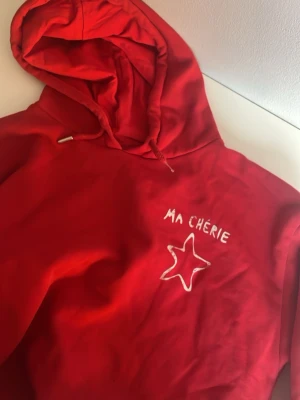 Röd hoodie - Röd ma cherie hoodie som ej säljs i butik längre. Använd 5 gånger. Metallsaken vid snöret är av