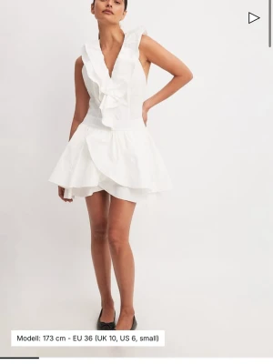 Vit volangklänning med öppen rygg - Säljer min fina klänning från NAKD i storlek 38, slutsåld på hemsidan i alla storlekar. Volangdetaljer och v-ringning fram, ärmlös och öppen rygg. Sitter så fint på kroppen och håller kvar den ”bubbliga” formen nedtill, och i ordentligt men luftigt material. Jag har endast använt den en gång 🩷 Passar perfekt som studentklänning eller finare sommarklänning! Kan skicka egna bilder om det önskas 😇