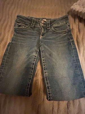  Blåa Bootcut jeans💗💗 - Säljer mina blåa boot jeans som är låg midja med vit sömn💗. samlar pengar för att ha råd med min dröm valp💗🥺