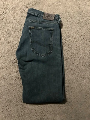 Lee jeans med raka ben - Snygga jeans från Lee med klassisk femficksdesign och raka ben. Jeansen har Lee-logga på bakfickan och patch i midjan. Tillverkade i slitstarkt denimtyg som passar perfekt till en avslappnad stil. Tyvärr är lapp för storlek bort klippt så storlek är okänd. Men uppskattar ca w30 SE MÅTT!