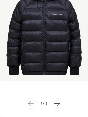 Svart dunjacka från Peak Performance - Snygg svart dunjacka från Peak Performance med quiltad design och diskret logga på bröstet. Jackan har dragkedja framtill, två sidofickor med dragkedja och ribbade muddar vid ärmar och nederkant. Perfekt för kalla vinterdagar. Knappt använd då jag köpte en annan istället ! Egna bilder fås vid intresse 💕