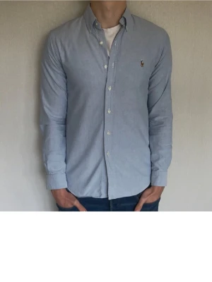 Ljusblå skjorta från Ralph Lauren - Klassisk ljusblå skjorta från Ralph Lauren. Fint skick och inga defekter! Inte jag på bilden!