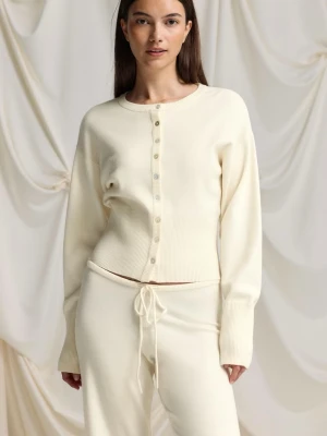 Krämvit ribbad kofta från Gina Tricot - Snygg krämvit kofta med rund hals och ribbade muddar från Gina Tricot. Koftan har knappar framtill och är tillverkad i ett mjukt stickat material. Perfekt att slänga över en topp för en chill look. Har inte kommit till användning 