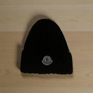 Moncler mössa - Svart moncler mössa. Varm mössa inför vintern med fin logga. Fin kvalitet och gör jobbet för att hålla en varm. Fler funderingar kan jag besvara privat 