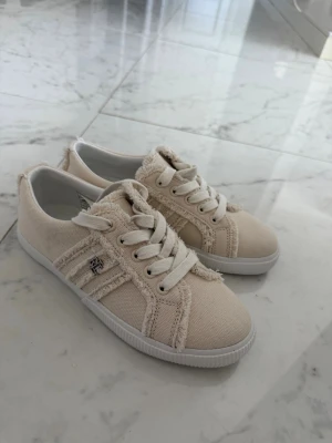 Beige sneakers från Ralph Lauren - Helt nya skor från Ralph lauren som säljs på grund av att jag fått andra skor  i present. Jättefina 