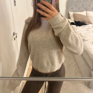 Beige croppad stickad tröja - Mysig och super mjuk beige stickad tröja med croppad passform och långa ärmar. Tröjan har en enkel design med ribbade muddar vid ärmslut och ner till.🩷