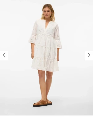 Vit student/sommar klänning kort/midi - Söt vit kortklänning med v-ringning och trekvartsärm. Klänningen har fina spetsdetaljer och broderade mönster, samt volanger som ger en luftig Perfekt för sommarens alla tillfällen. Köpte för 699 och prislappen är kvar