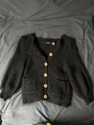 Svart kofta från ella&il med träknappar - Mysig svart kofta med stora träfärgade knappar framtill. 70% mohair och 30% ull❣️