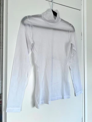 Y2K vit mesh-tröja / sheer top - mycket bra, stl S - Vit mesh-tröja med turtle neck / hög hals. Genomskinlig och perfekt att styla över/under toppar för en Y2K-look - bralettes / linnen. Mycket stretch! Mycket bra skick och normal i storleken. 