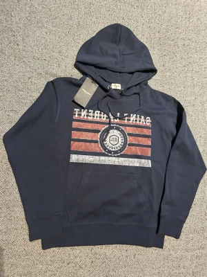 Mörkblå hoodie från Saint Laurent - Snygg marinblå hoodie från Saint Laurent med tryck i vitt och rött framtill. Tveka inte på att höra av dig vid prisförslag eller frågor. jag fraktar samma dag✅ Kvitto finns!