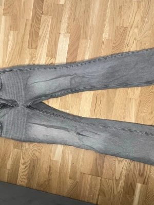 Gråa bootcut-jeans från Perfect Jeans - Snygga gråa bootcut-jeans från Perfect Jeans med klassisk femficksdesign och dragkedjegylf. Jeansen har en lätt tvättad look och raka ben som blir vidare nedtill. Perfekta för en avslappnad och trendig stil.