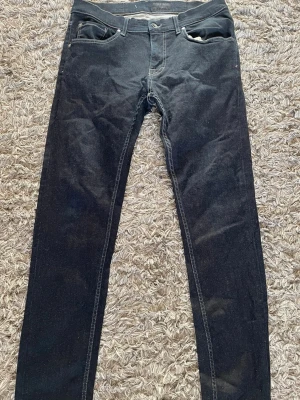 Tiger of Sweden jeans  - Säljer ett par marinblå jeans från Tiger of Sweden med klassisk femficksmodell och raka ben. Jeansen har en snygg, enkel design och är tillverkade i slitstark denim. Perfekta för dig som gillar stilrena och tidlösa plagg.