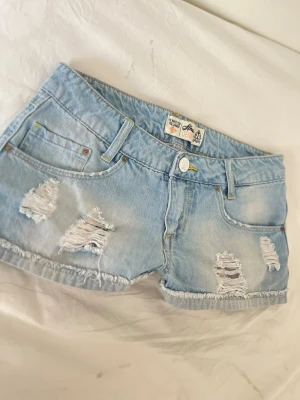 M5 Ljusblåa lowrise stretchiga lågmidjade jeanshorts - Midja ca 35,5 gren ca 18 cm