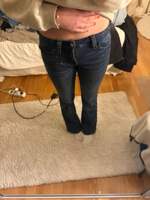 Mörkblå bootcut jeans - Säljer ett par mörkblå bootcut jeans med klassisk femficksmodell och normalhög midja. Jeansen har en snygg tvätt och raka ben som går ut lite nedtill. Perfekta till sneakers eller boots och passar till det mesta i garderoben.