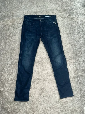 Mörkblå skinny jeans från Replay - Snygga mörkblå slim fit jeans från Replay. Jeansen har en smal passform och är tillverkade i stretchigt denimtyg för extra komfort. Perfekta till en avslappnad streetstyle-look.