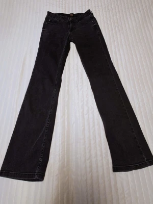 Svarta bootcut jeans från Lee - Säljer ett par svarta bootcut jeans från Lee med klassisk femficksmodell och normal midja. Jeansen är välskötta och i fint skick.