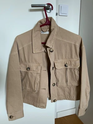 Beige jeansjacka - Beige croppad jeansjacka från GinaTricot. 
