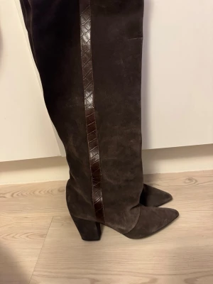 Twist and tango boots  - Ett par bruna Twist and Tango stövlar i mocka med bred klack och spetsig tå. Klacken är 8 cm hög och är till och med omklackade. Använt fåtal gånger. Nypris 3 699kr, säljer för 2399kr