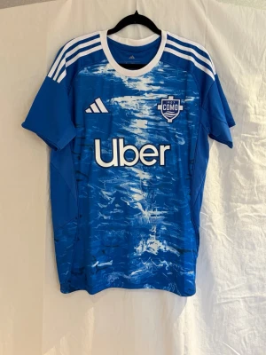 Blå Como 1907 matchtröja Adidas - Säljer Como 1907 hemmatröja från årets säsong 👕  På ryggen finns Adrian Lahdo – tidigare Hammarby-spelare som slog igenom i Allsvenskan. Förra säsongen stod han för 12 matcher och 4 poäng innan han blev värvad av italienska Como 🇮🇹  En riktigt unik tröja med en spännande spelare som är i början av sin karriär utomlands – perfekt för samlare eller dig som vill ha något annorlunda.  