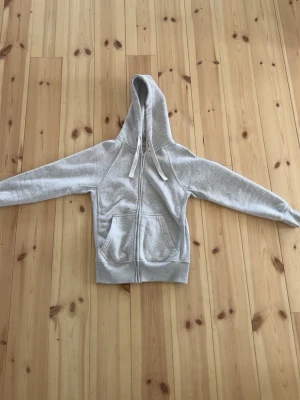 Ljusgrå hoodie från Russemerch  - Säljer en ljusgrå hoodie från Russemerch  med dragkedja framtill. Säljer då jag aldrig använder och ska köpa en Anna färg. Pris kan diskuteras! Stolek s! 