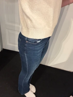 Mörkblå bootcut jeans - Säljer ett par mörkblå bootcut jeans med klassisk femficksdesign och normal midja. Jeansen har en snygg tvätt och är tillverkade i stretchigt denimtyg som sitter bekvämt. Perfekta för en avslappnad och trendig look.