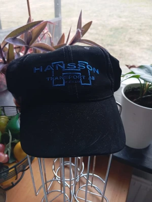 Ny keps med böjd skärm - Snygg svart keps med böjd skärm och justerbar rem bak. Enkel och stilren design som passar till det mesta. Tillverkad i bomullstyg för en bekväm känsla hela dagen.