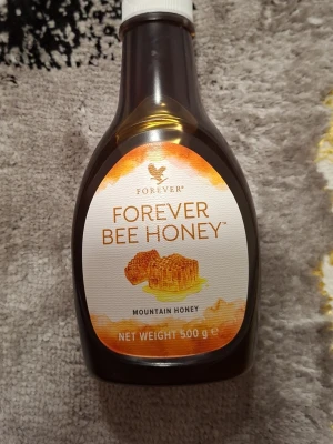 Forever Bee Honey bergshonung 500g - Säljer en flaska Forever Bee Honey, flytande mörk bergshonung från Spanien. Kommer i en plastflaska med orange och vit etikett, innehåller 500g honung med blommig doft och fruktig smak. Perfekt till te, bakning eller som sötning i mat.
