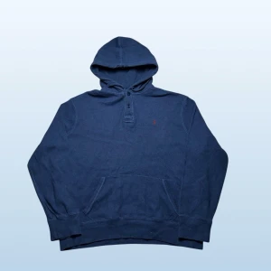Vintage Ralph Lauren 1/4 button up hoodie - herr strl XL - Säljer en vintage Ralph Lauren 1/4 button up hoodie i marinblå färg i storlek XL med vinröd broderad Ralph Lauren logga på vänster sida av bröstkorgen.  👕 Märke: Ralph Lauren 📏 Storlek: XL 🎨 Färg: Marinblå 🧵 Material: 100% bomull 📐 Mått: 71 cm lång, 71 cm bred 📌 Skick: Mycket bra skick (se bilder)  💬 Hör av dig vid frågor 💰 Pris kan diskuteras vid snabb affär 📦 Skickas inom 24 timmar
