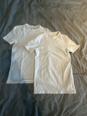 Vita basic t-shirts från H&M - 2-pack t-shirts, klassiska pipeline vita t-shirts från H&M med rund hals och korta ärmar. tillverkade i mjuk bomull för skön känsla. Pass dare till både jeans och shorts. Tyget är stretchigt och man ka töja ut den.