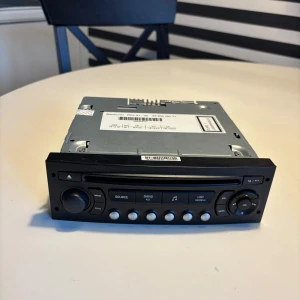 Bilradio RDD N1-02 med CD-spelare - Säljer en bilradio RDD N1-02 med inbyggd CD-spelare och flera knappar för ljudinställningar. Fronten är svart med tydliga symboler och volymratt. Höljet är i metall och passar för inbyggnad i bilens mittkonsol. Perfekt för dig som vill ha musik på vägen.