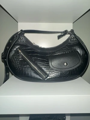 Svart croco axelväska med fickor - Säljer min svarta axelväska från Bik bok som inte kommer till användning.