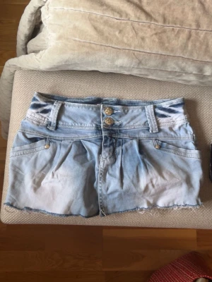 Ljusblå jeanskjol med slitna detaljer från gourd - Säljer en kort ljusblå jeanskjol med slitna kanter och dubbla knappar framtill. Kjolen har fickor både fram och bak samt bälteshällor. Dock har jag klippt den själv då den var väldigt lång så fickorna där fram funkar inte (syns inte) men bakfickorna gör det. Perfekt nu för sommaren!!💛💛💛 Passar både XS och S. Tar gärna emot prisförslag!!💛💛
