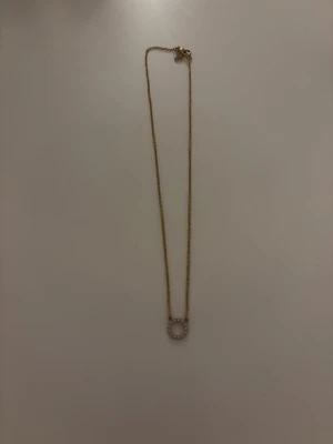 Guldhalsband med cirkelhänge - Snyggt halsband i guld med ett cirkelformat hänge. Kedjan är tunn och elegant, vilket gör halsbandet stilrent och lätt att matcha med andra smycken. Perfekt för dig som gillar minimalistisk design.