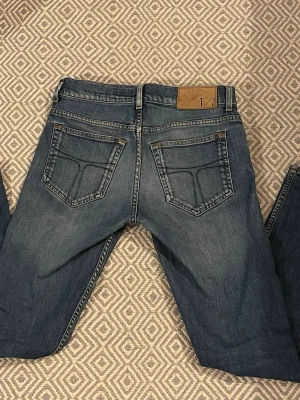 Tiger of Sweden jeans - Säljer ett par klassiska blå jeans från Tiger of Sweden T/J med snygg tvätt och raka ben. Längden är L32. Riktigt go Grisch stil, kontakta om intresse!!