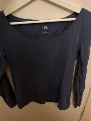 Mörkblå långärmad topp från 157 - En enkel och stilren mörkblå långärmad topp från 157. Tillverkad sopm en klassisk  add-on till garderoben, med rund halsringning och mjukt bomullsmaterial. Perfekt att matcha med jeans eller kjol.