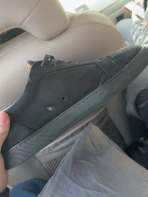 Christian loubitin - Snygga svarta sneakers med lågt skaft och klassisk design. Skon har ovandel i canvas och gummisula, samt svarta skosnören och metallhål för snörning. Perfekt för en stilren och avslappnad look.