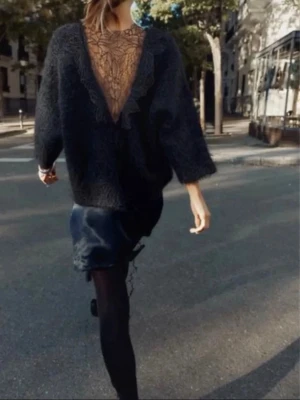 Svart stickad tröja med spetsdetalj - Säljer en suuperfin svart oversized stickad tröja med spetsdetalj på ryggen från zara. Den har trekvartsärmar. Perfekt för våren eller kalla sommarkvällar 😊🙌💗 Aldrig använt! Köpt ny för 700kr