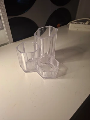 Transparent pennställ i plast - Säljer ett transparent pennställ i plast med tre fack i olika höjder och former. Perfekt för att organisera pennor, penslar eller småsaker på skrivbordet. Modern och stilren design som passar in i de flesta rum.