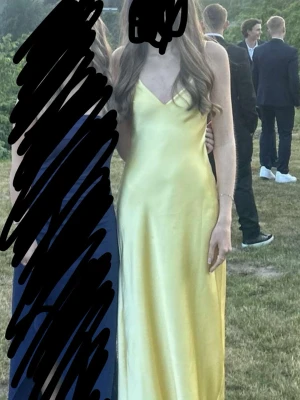 Lång gul klänning med v-ringning från zara  - Säljer en elegant lång klänning i ljus gul färg med v-ringad hals och smala axelband. Klänningen har en slät och glansig yta som ger ett lyxigt intryck, perfekt för speciella tillfällen. Materialet känns mjukt och följsamt mot kroppen. Jag är 170 cm för referens, använd 1 gång, köpt ifrån zara, perfekt för bal, avslutning, fest eller annat. Den har fläck på magen, men syns inte jätte tydligt, i vissa ljus. Och vet inte vart det kommer ifrån, då jag inte spillt på den och bara använts en gång. 