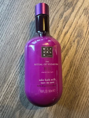 Rituals The Ritual of Yozakura badmjölk - Lyxig badmjölk från Rituals i serien The Ritual of Yozakura. Flaskan är lila med svart och lila lock och rymmer 500 ml. Innehåller sake och yoshino cherry för en avslappnande badupplevelse.