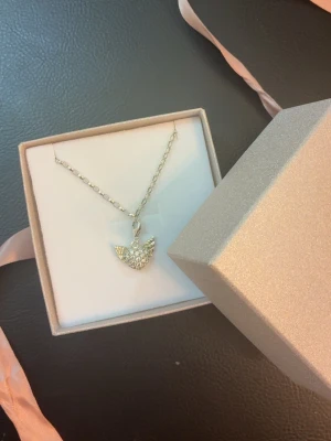 Silverfärgad vinge-hjärta armband Thomas Sabo - Säljer ett snyggt charm armband från Thomas Sabo med ett charmigt hjärta med vingar, täckt av glittrande stenar. Hängsmycket är i sterling silver 925s och kommer i en lyxig glitter ask med en rosa rosett. Helt nytt skick. Orginalpris: 749kr Mitt pris: 549kr