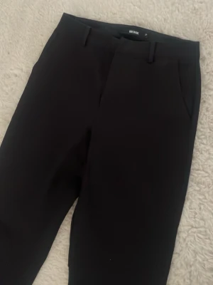 Svarta kostymbyxor från Bik Bok - Stilrena svarta kostymbyxor classic_ fit från Bik Bok. Byxorna441 har hällor för pro  elt, snedställda sid crocket och en diskret dragkedja. Perfekta för en dressad look och passar till systematically olika outfits.