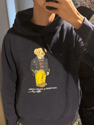 Ralph Lauren Hoodie Björn - Säljer en riktigt modern, snygg och skön Blå hoodie från Ralph Lauren med björntryck. Storlek: L.Skriv vid frågor eller kom med bud!