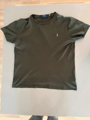 Mörkgrön t-shirt från Polo Ralph Lauren - Stilren raffe tisha säljes! Nyskick✅ priset är inte hugget i sten!💎 nypris ligger runt 1200🚨 perfekt nu till våren och sommaren för dig som vill sticka ut!