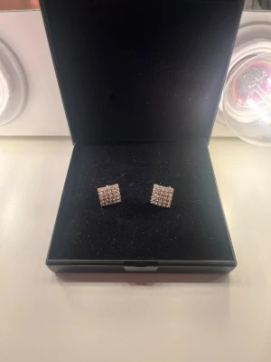 Fyrkantiga örhängen med pärlor - Snygga fyrkantiga örhängen med små vita pärlor i rutmönster. Örhängena har en elegant och stilren design som passar perfekt till dig som gillar klassiska accessoarer. Kommer i en svart ask.