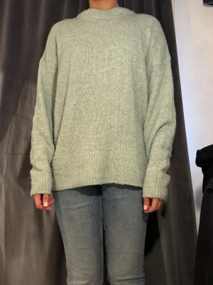 Ljusgrön oversized stickad tröja - Mysig ljusgrå stickad tröja i oversized modell med rund halsringning och långa ärmar. Från lager 157 storlek S