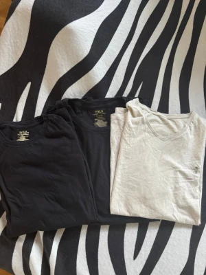 3-pack t-shirts från Polo Ralph Lauren - Tre klassiska t-shirts från Polo Ralph Lauren, två svarta och en ljusgrå. Alla har kort ärm och diskret logga broderad på bröstet. Sköna och stilrena, perfekta till jeans eller shorts. Tillverkade i mjuk bomull för maximal komfort.