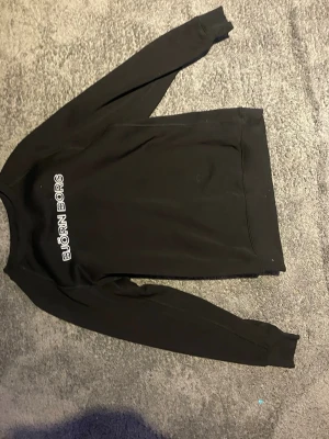Svart Björn Borg sweatshirt - Svart sweatshirt från Björn Borg med vit logotyp på bröstet. Klassisk rund halsringning och långa ärmar med ribbade muddar. Perfekt för en avslappnad och sportig stil. Det är barn storlek 170 inte S men passar som S 