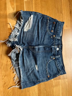 Levis 501 jeansshorts - Jeansshorts från Levis, modell 501. Strl 25. Midjemått tvärsöver ca 34 cm enligt bild. 
